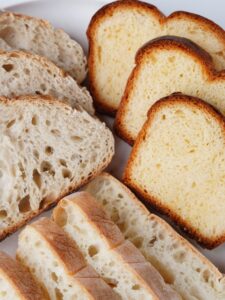 Close-up of assorted fresh bread slices, highlighting textures and variety, perfect for bakery promotions.